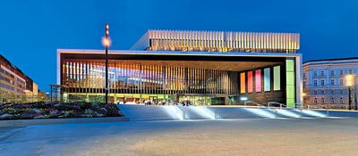 Moderne Architektur mit beleuchtetem Gebäude und Treppen bei Nacht.