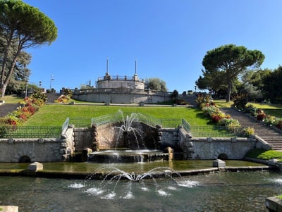 Brunnen und Treppen in einer gepflegten Parklandschaft.