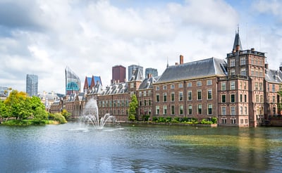 Historische Gebäude am Wasser mit Springbrunnen in Den Haag.