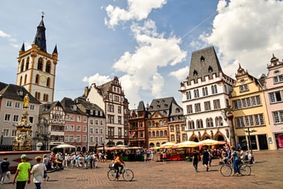 Menschen auf belebtem Platz mit historischen Gebäuden.