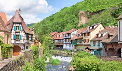 Malerisches Dorf mit Fachwerkhäusern entlang eines Baches.
