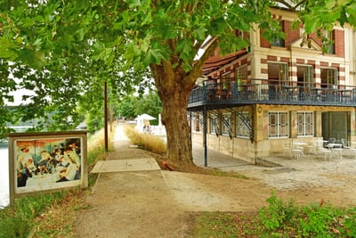 Pfad neben einem Baum und einem Gebäude mit Balkon, Kunstwerk im Freien ausgestellt.
