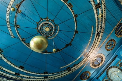 Blaue Decke mit astronomischen Markierungen und goldener Kugel.