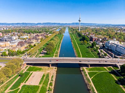 Luftbild von Kanal, Brücke und Fernsehturm in städtischer Landschaft.