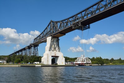 Grosse Eisenbahnbrücke über einen Fluss mit blauen Himmel und einigen Wolken.