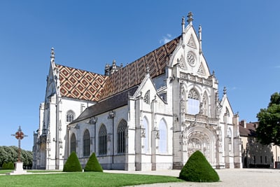 Gotische Kathedrale mit buntem Dach bei sonnigem Himmel.
