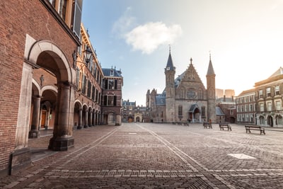 Historischer Platz mit Backsteingebäuden und Kirche bei Sonnenaufgang.