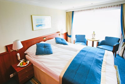 twerenbold_21546.jpg Hotelzimmer mit Doppelbett und blauen Akzenten.