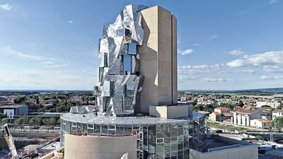 Modernes Gebäude mit unregelmässiger Fassade in städtischer Umgebung.
