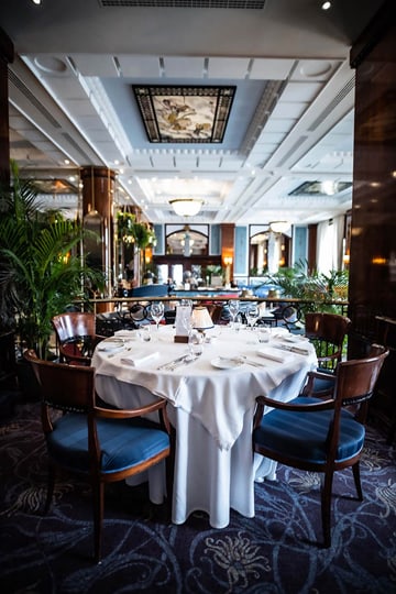Elegantes Restaurant mit einem gedeckten Tisch und Holzstühlen.
