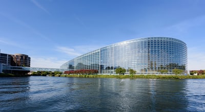 Moderne Glasgebäude am Flussufer bei klarem Himmel.