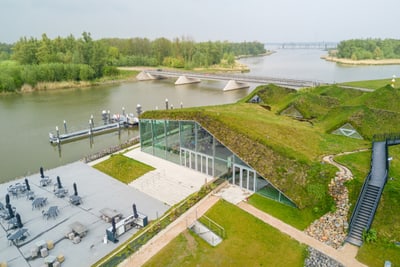 Modernes Gebäude mit begrüntem Dach am Flussufer.