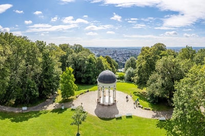 Panoramaansicht eines Parks mit Pavillon und Bäumen.