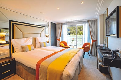 twerenbold_85848.jpg Luxuriöses Hotelzimmer mit Doppelbett und Flussblick.