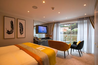 Modernes Hotelzimmer mit Doppelbett, Fernseher und grossem Fenster.