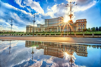 Historisches Gebäude bei Sonnenuntergang mit Spiegelung im Wasser.