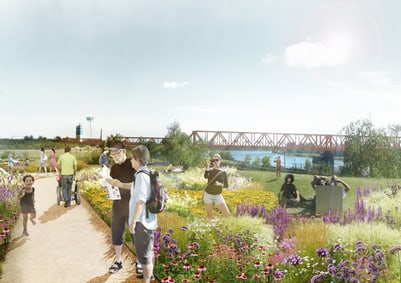 Menschen spazieren auf einem Weg durch einen blühenden Garten mit Brücke im Hintergrund.
