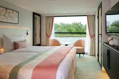 twerenbold_99796.jpg Elegantes Hotelzimmer mit grossem Fenster und grünem Ausblick.