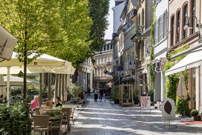 Belebte Fussgängerzone mit Cafés und Geschäften.