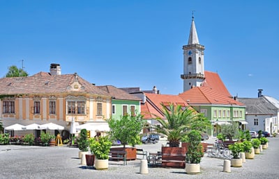 Historischer Platz mit bunten Gebäuden und Turm.