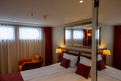 twerenbold_85773.jpg Helles Hotelzimmer mit Doppelbett und Sessel.