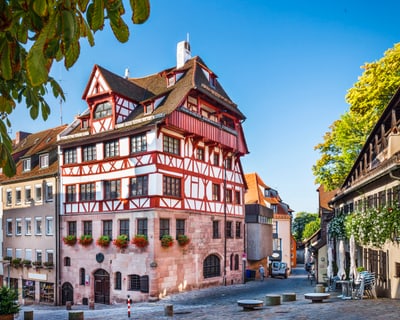 Historisches Fachwerkhaus an einem sonnigen Tag auf einem Kopfsteinpflasterplatz.
