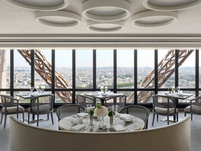 Elegantes Restaurant mit Blick auf die Stadt durch grosse Fenster.
