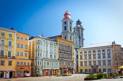 Farbenfrohe historische Gebäude und Kirche auf einem Platz.