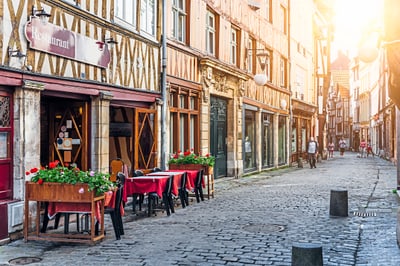 Strassencafé in malerischer Gasse mit Fachwerkhäusern.