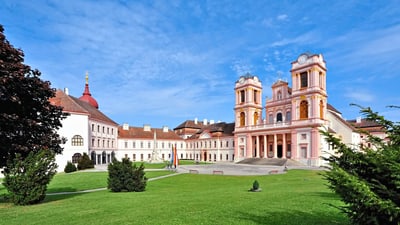 Barockkloster mit weitläufigem Rasen und blauem Himmel.
