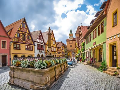 Malerische Altstadt mit Fachwerkhäusern und Kopfsteinpflasterstrasse, wenige Menschen spazieren.