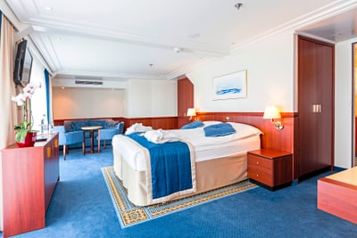 Moderner Hotelraum mit Doppelbett und Sitzecke.