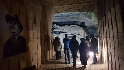Menschen gehen durch einen Tunnel mit Wandgemälden.