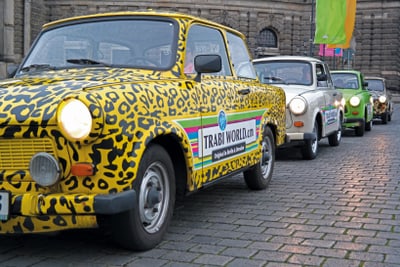 Reihe von Trabant-Autos auf Kopfsteinpflasterstrasse.