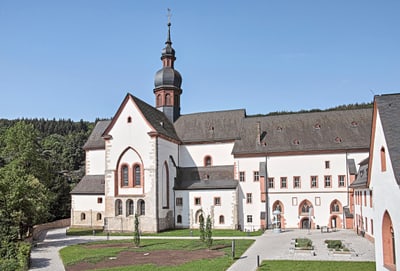 Historisches Klostergebäude mit Turm und Hof.