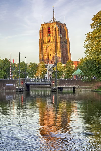 Grosser Backsteinturm mit Wasser reflektiert im Vordergrund.
