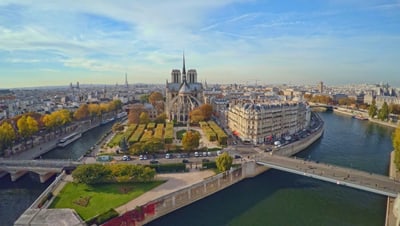 Luftaufnahme einer Stadt mit Fluss und historischer Kathedrale im Zentrum.