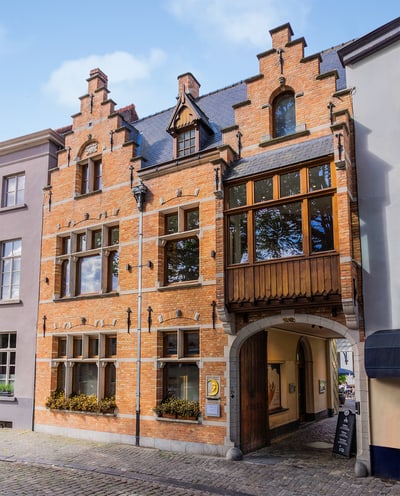 Historische Backsteinfassade mit Torbogen in einer Stadtstrasse.