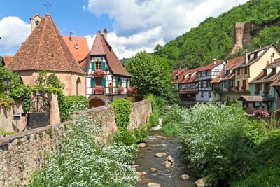 Malerisches Dorf mit Fachwerkhäusern an einem kleinen Fluss.