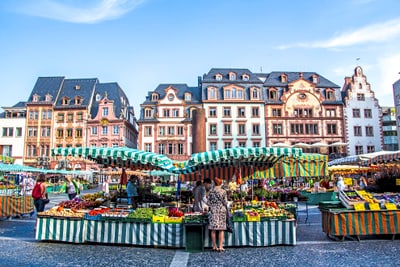 Bunter Marktplatz mit historischen Gebäuden im Hintergrund.