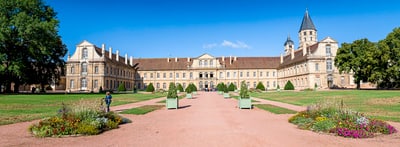 Historisches Schloss mit Garten und blauem Himmel.