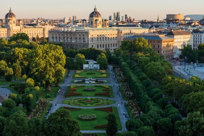 Schlossgarten und historische Gebäude in Wien bei Sonnenuntergang.