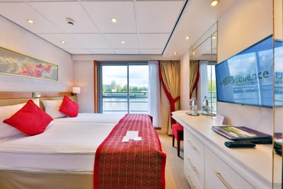 Luxuriöses Kabinenzimmer mit Flussblick und roter Bettdecke.