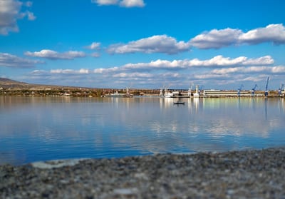 Serene-Landschaft-mit-klares-Wasser-und-Hafenkränen-im-Hintergrund.