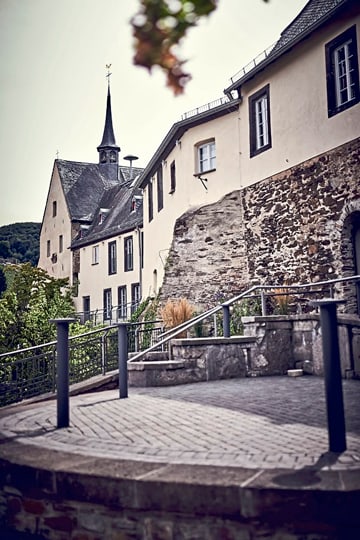 Historisches Gebäude mit gepflastertem Weg und Treppe im Vordergrund.