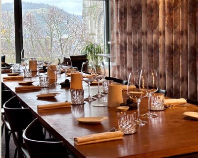 Elegant gedeckter Tisch in einem Restaurant mit Aussicht auf Bäume.