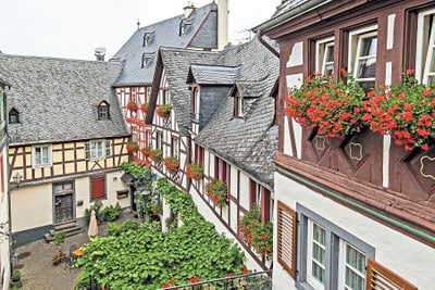 Fachwerkhäuser mit Blumen in einem Innenhof.