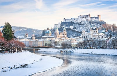 staedte-im-sternenlicht-ulm-wien-salzburg-7.jpg Winteransicht der verschneiten Stadt Salzburg mit Festung, Fluss und Gebäuden.