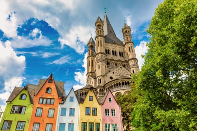 Bunte Häuser und Kirche im Hintergrund unter blauem Himmel.