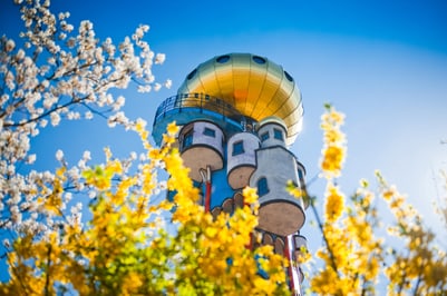 Bunter Turm hinter blühenden Bäumen im Frühjahr.